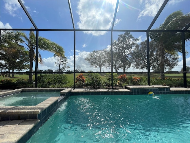 view of pool featuring a lanai, a pool with connected hot tub, and a patio