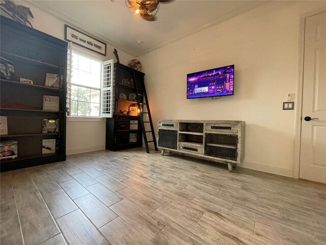 bedroom featuring baseboards, crown molding, and wood finished floors