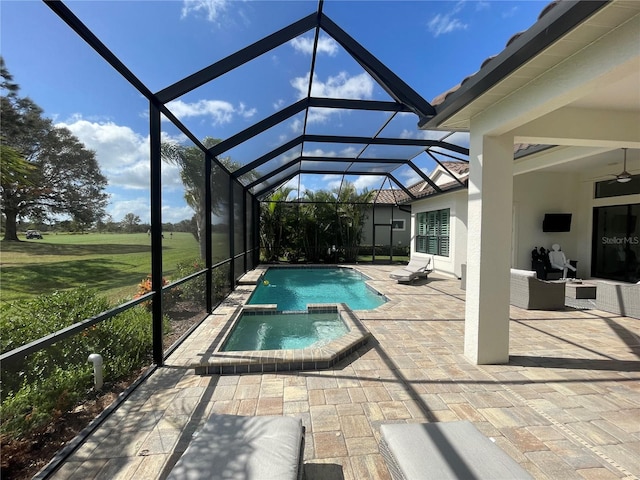 view of pool with a patio, a pool with connected hot tub, a ceiling fan, and glass enclosure