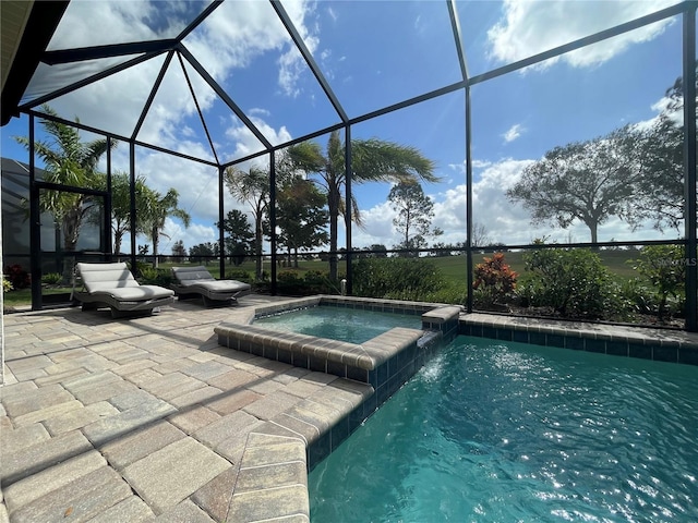 view of swimming pool with a patio area, a pool with connected hot tub, and a lanai