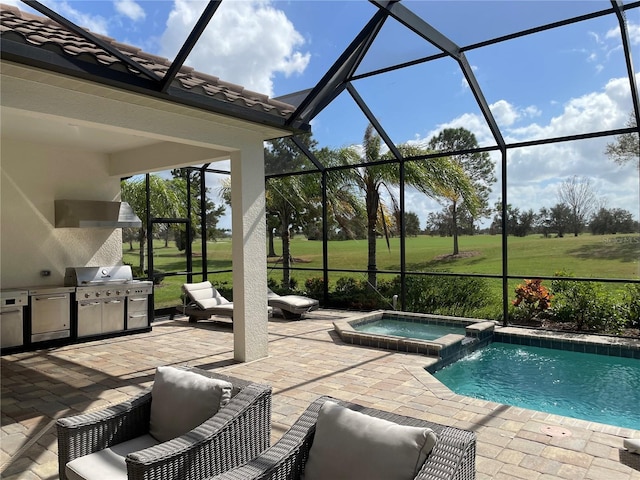 view of swimming pool with an outdoor kitchen, a patio, a pool with connected hot tub, and a lanai