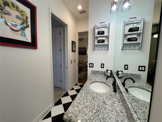bathroom featuring a notable chandelier, tile patterned floors, visible vents, and a sink
