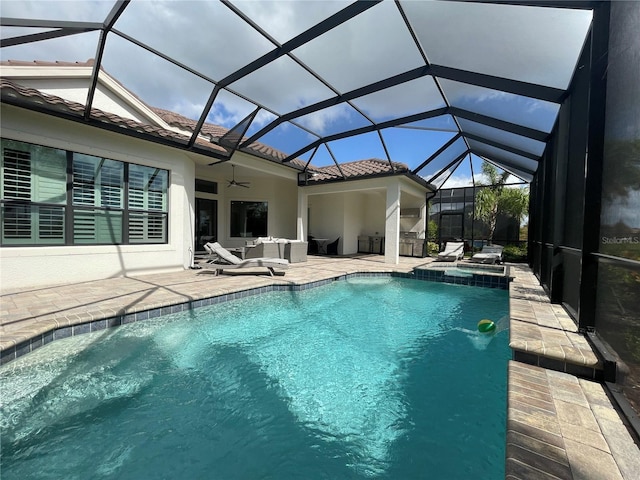 view of swimming pool featuring an outdoor living space, ceiling fan, a pool with connected hot tub, a patio area, and glass enclosure