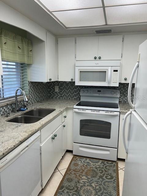 3751 S School Ave Unit 29, Sarasota, FL 34239 - kitchen with white appliances, a sink, light tile patterned floors, and backsplash