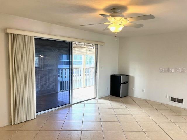 3751 S School Ave Unit 29, Sarasota, FL 34239 - empty room with a ceiling fan and light tile patterned flooring