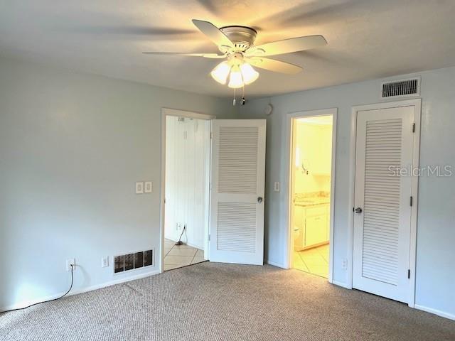 3751 S School Ave Unit 29, Sarasota, FL 34239 - unfurnished bedroom with carpet floors, connected bathroom, a ceiling fan, and baseboards