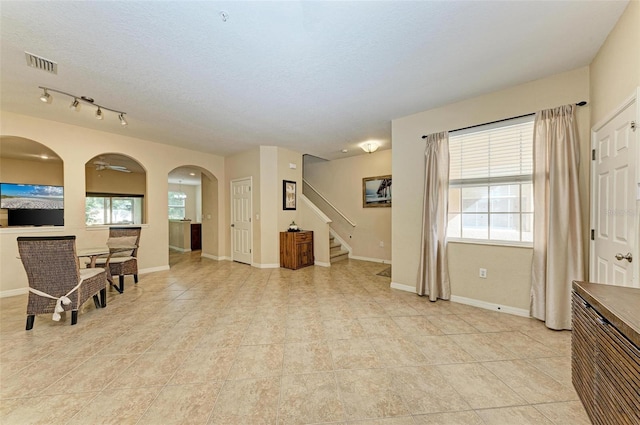 interior space featuring a wealth of natural light, a textured ceiling, and light tile patterned flooring