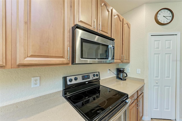 kitchen featuring light brown cabinets and black / electric stove