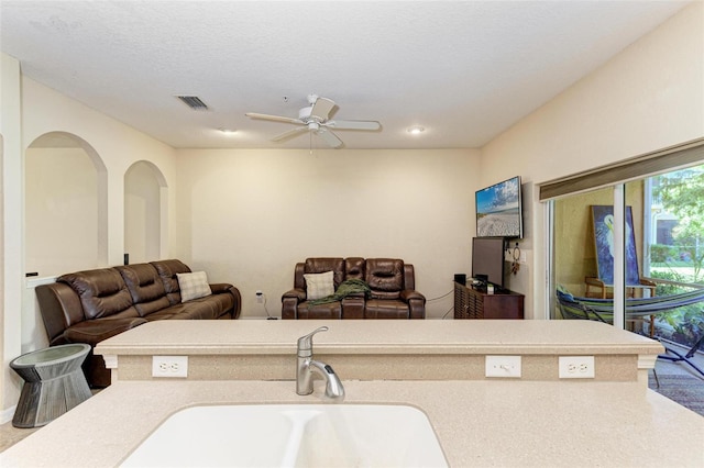 kitchen featuring sink, a textured ceiling, and ceiling fan