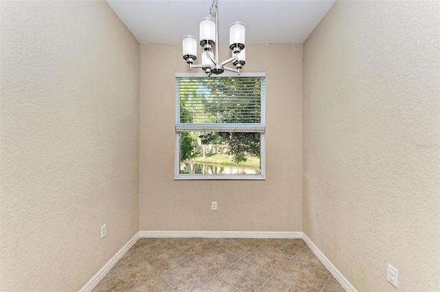 spare room with a chandelier