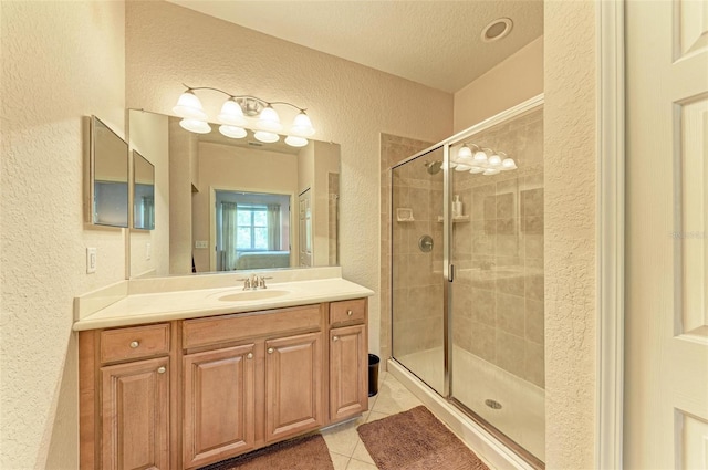 bathroom featuring vanity, a textured ceiling, tile patterned flooring, and a shower with shower door