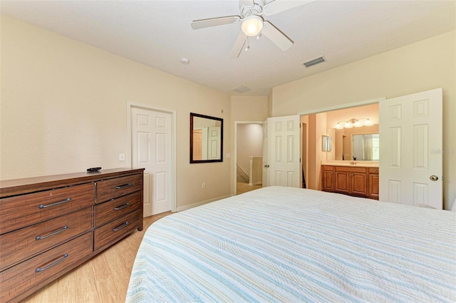 bedroom featuring light wood-type flooring, ceiling fan, and ensuite bath