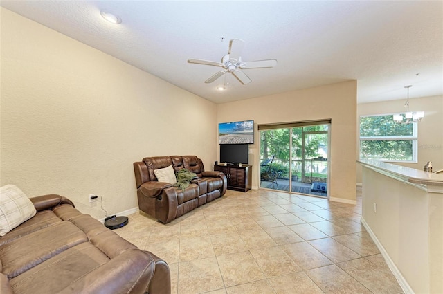 tiled living room featuring ceiling fan with notable chandelier