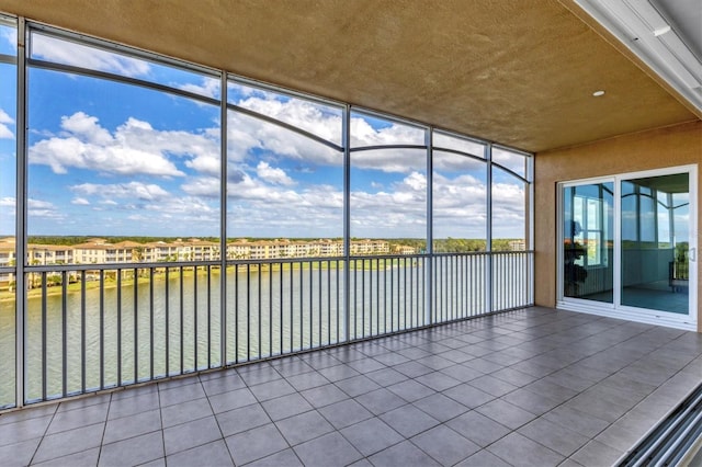 unfurnished sunroom featuring a water view