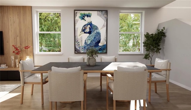 dining room featuring breakfast area, baseboards, and wood finished floors