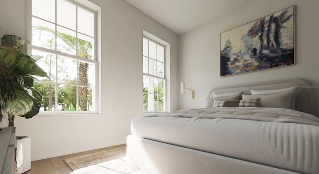 bedroom with multiple windows and wood finished floors