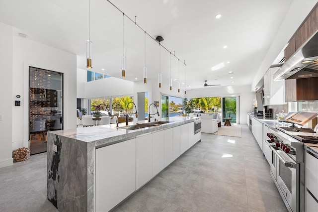 kitchen featuring white cabinetry, range with two ovens, and hanging light fixtures