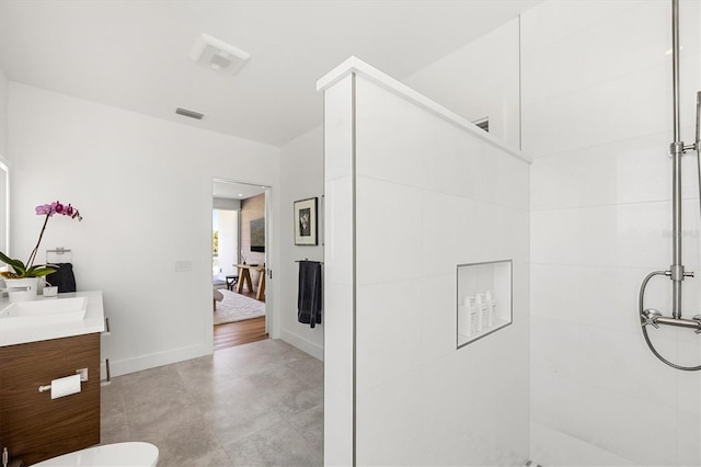 bathroom with a shower, vanity, and toilet