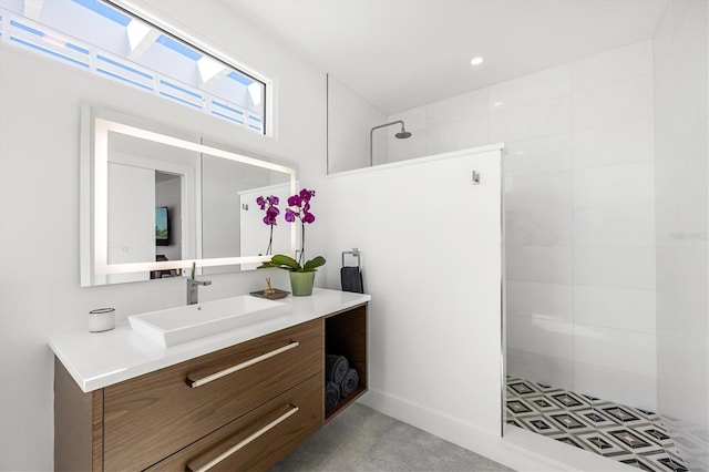 bathroom featuring tiled shower and vanity