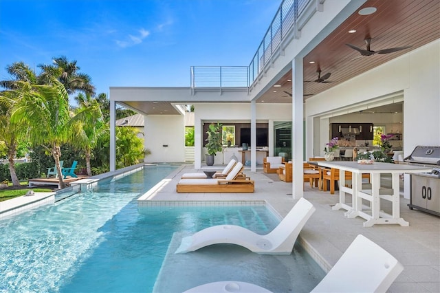 view of swimming pool with ceiling fan, area for grilling, an outdoor bar, and a patio