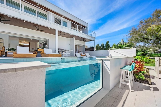 view of swimming pool with a patio, an outdoor bar, ceiling fan, and exterior kitchen