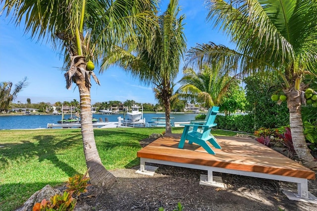 view of home's community featuring a lawn, a water view, and a dock