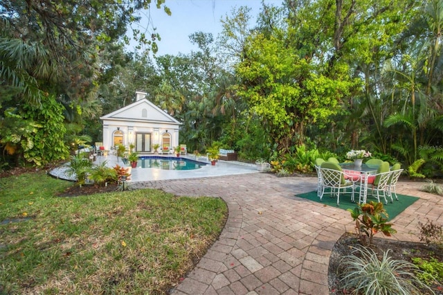 view of swimming pool with a patio and an outbuilding