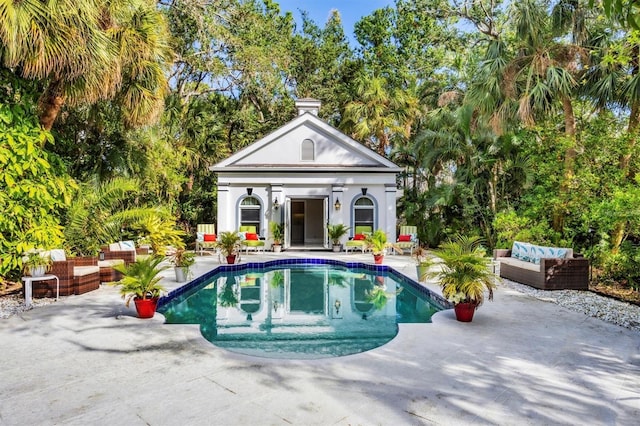 view of pool with a patio, an outdoor hangout area, and an outdoor structure