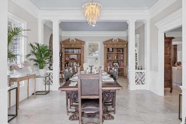 dining area featuring an inviting chandelier, crown molding, and ornate columns