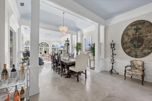 dining room featuring decorative columns, crown molding, and a chandelier