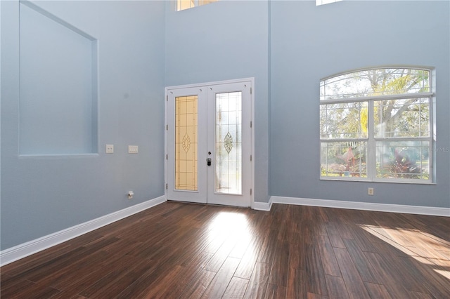 entryway with a towering ceiling, dark hardwood / wood-style floors, and french doors