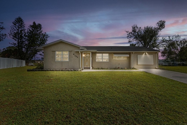 ranch-style home featuring a lawn and a garage