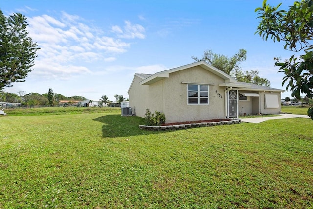 view of front of property with central AC and a front lawn