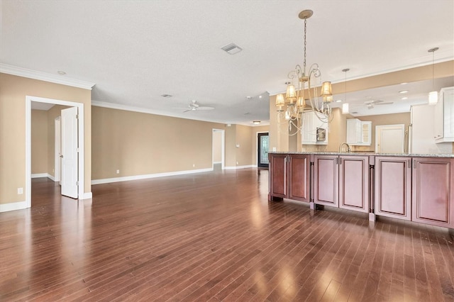 kitchen featuring ceiling fan with notable chandelier, pendant lighting, dark hardwood / wood-style flooring, and ornamental molding