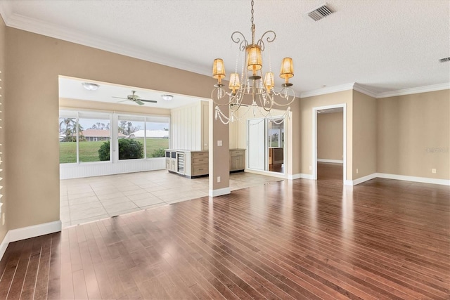 unfurnished dining area featuring crown molding, hardwood / wood-style floors, ceiling fan with notable chandelier, and a textured ceiling