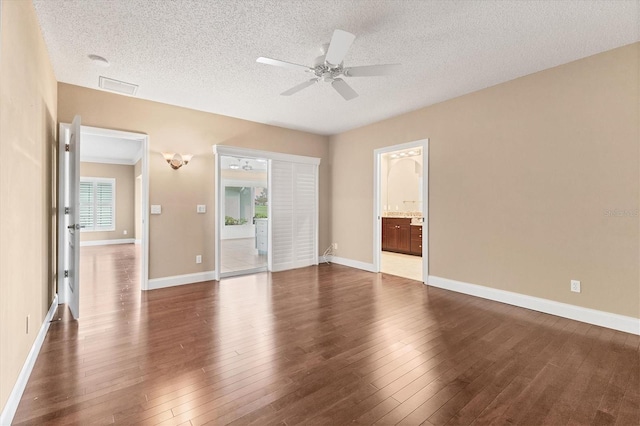 unfurnished room featuring ceiling fan, dark wood-type flooring, and a textured ceiling