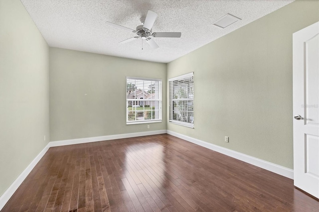 spare room featuring dark hardwood / wood-style floors, ceiling fan, and a textured ceiling