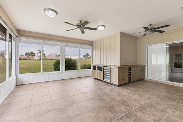 unfurnished sunroom with wine cooler and ceiling fan