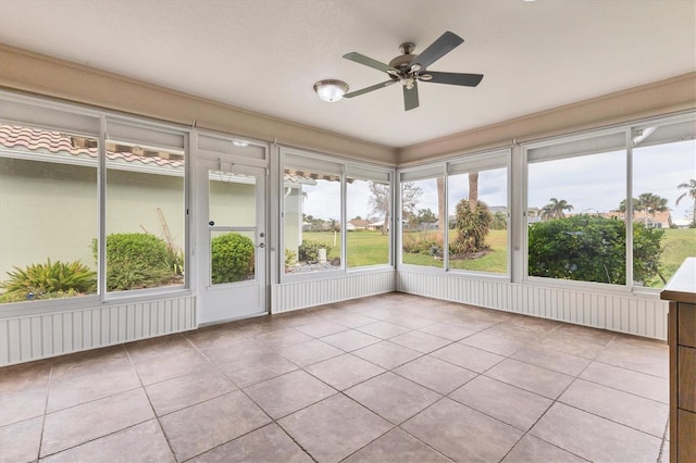 unfurnished sunroom featuring ceiling fan and a healthy amount of sunlight