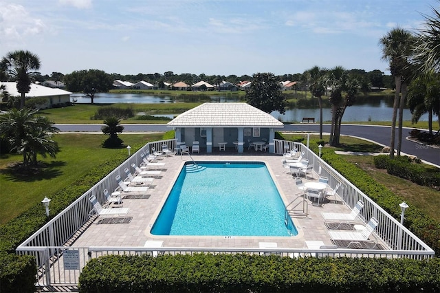 view of pool with a yard, a water view, and a patio