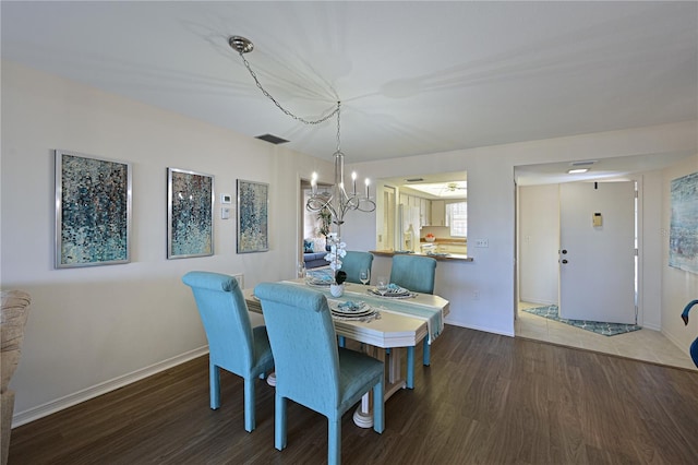 dining room featuring baseboards, visible vents, a chandelier, and dark wood-style flooring