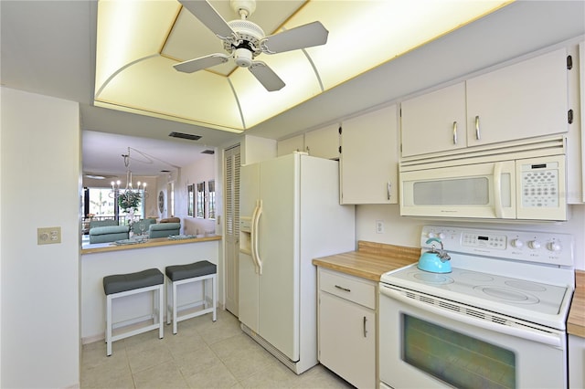 kitchen with light tile patterned floors, light countertops, white cabinets, white appliances, and ceiling fan with notable chandelier