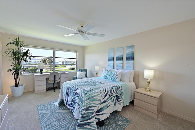 bedroom with light carpet, ceiling fan, and baseboards