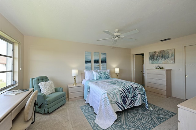 bedroom with ceiling fan, a textured ceiling, visible vents, and light colored carpet