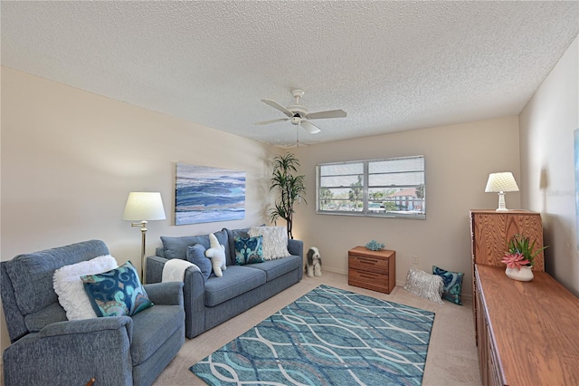 living area with light carpet, ceiling fan, and a textured ceiling