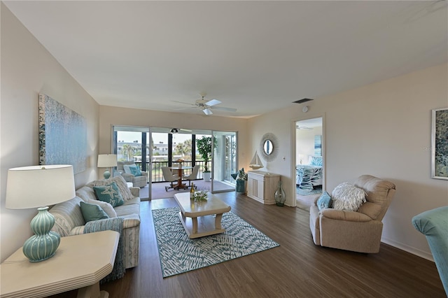 living room featuring ceiling fan, dark wood-type flooring, and baseboards