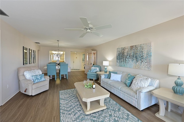 living area with dark wood-style floors, visible vents, baseboards, and ceiling fan with notable chandelier