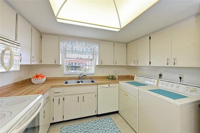 washroom featuring light tile patterned floors, washer and clothes dryer, and a sink