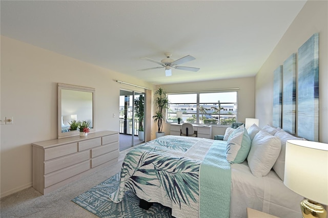 bedroom with access to exterior, light colored carpet, multiple windows, and a ceiling fan