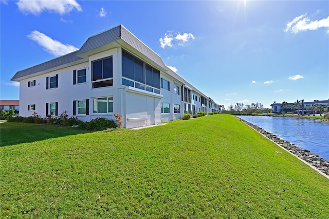 view of side of property featuring a water view and a yard